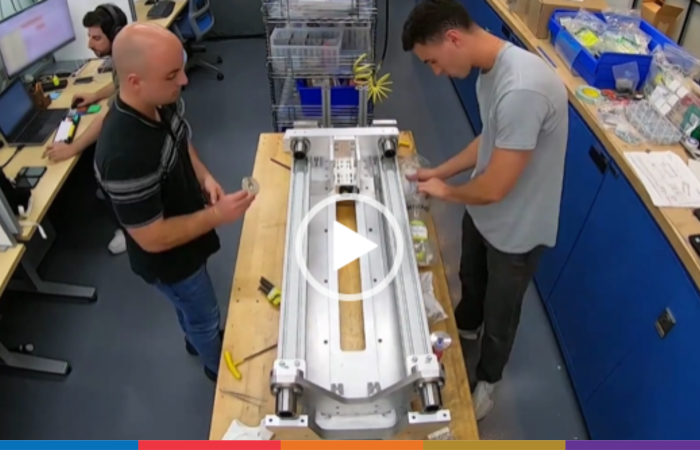 Two employees working on a machine on a workbench